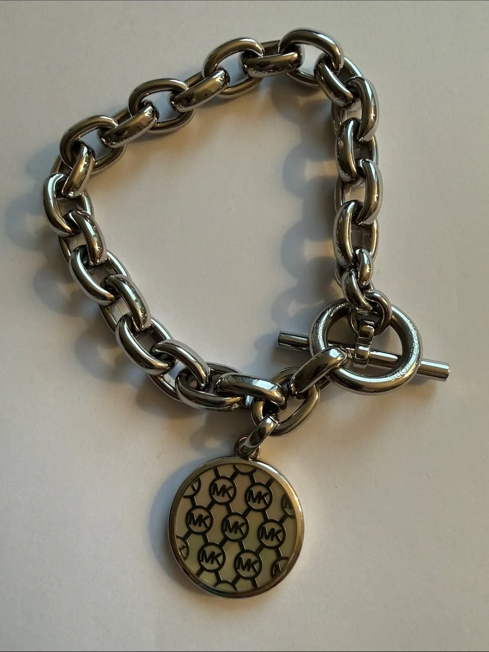 Michael Kors Silver-tone Toggle Bracelet with Dual Sided Logo Charm.